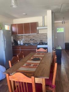 een keuken met een lange houten tafel en stoelen bij Casa Lago Argentino in El Calafate
