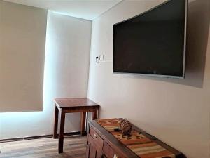 een kamer met een tv aan de muur en een tafel bij Casa Lago Argentino in El Calafate +5 foto's