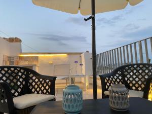 a table with two chairs and an umbrella on a balcony at In centro da Cinzia in Ostuni