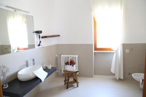 a white bathroom with a sink and a mirror at Virò House in Squinzano