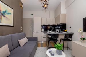 un salon avec un canapé et une cuisine dans l'établissement IRENE APARTMENT, à Alexandroúpolis