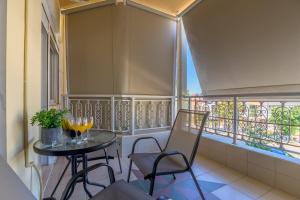 d'un balcon avec une table, des chaises et des fenêtres. dans l'établissement IRENE APARTMENT, à Alexandroúpolis