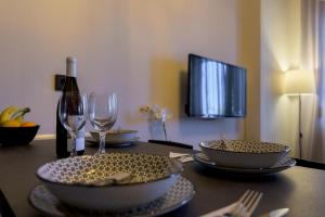 - une table avec 2 bols et une bouteille de vin dans l'établissement IRENE APARTMENT, à Alexandroúpolis