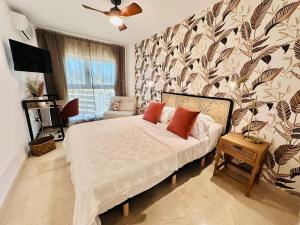 a bedroom with a bed and a wall with a leaf pattern at T1104 - Atrium Beach 3 - 2004 Finestrat in Cala de Finestrat