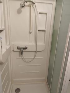 a shower in a bathroom with a white door at studio des roses in Gournay-en-Bray