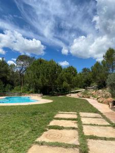 une cour avec une piscine et un ciel nuageux dans l'établissement Cal Masses , St. Salvador de Guardiola, à Guardiola
