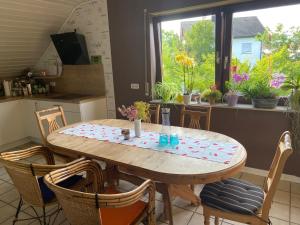 a table and chairs in a kitchen with a window at Zauber-Appartment in Krombach +10 photos