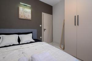 une chambre avec un grand lit avec des oreillers blancs dans l'établissement IRENE APARTMENT, à Alexandroúpolis