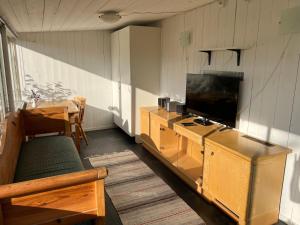 a living room with a television and a table with a couch at Villa Lullyhill in Visby