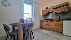 a kitchen with a table with chairs and a clock on the wall at Apartament przy zlocie in Borne Sulinowo