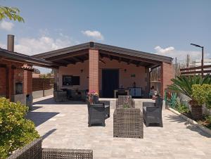 a patio with chairs and tables and a building at Cirica Relax in Santa Maria Del Focallo