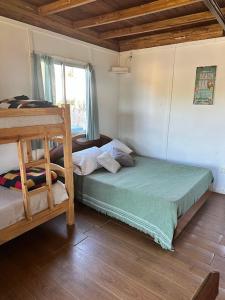 a bedroom with two bunk beds and a window at Complejo Anjuá in Punta Del Diablo +14 photos