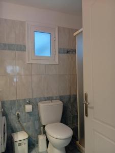 a bathroom with a toilet and a window at Leonidas Apartments in Preveza +23 photos