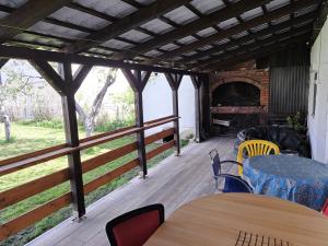 a screened porch with tables and chairs and a fireplace at Home of nature - Kuća prirode in Odžak