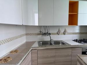 a kitchen with white cabinets and a sink at Harmonia Apartment with breathtaking view and a perfect location in Tropea
