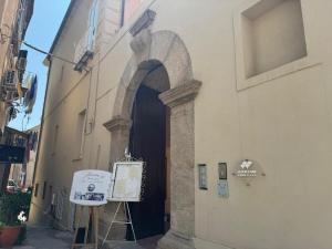 a doorway to a building with a sign in front at Harmonia Apartment with breathtaking view and a perfect location in Tropea
