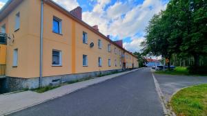 a yellow building on the side of a street at Apartament przy zlocie in Borne Sulinowo