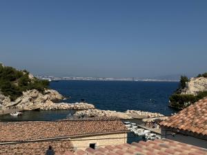a view of the ocean from the roofs of buildings at niolonlabricotier vue direct sur la mer in Le Rove