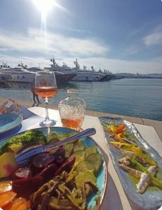 a table with a plate of food and a glass of wine at Spacious 2BR by Floisvos Beach Saltwater Balcony in Athens