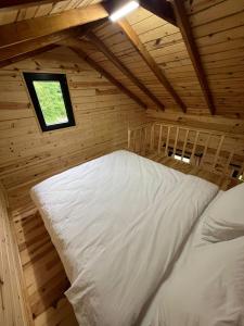 a bed in a wooden room with a window at Ali's House 61 in Anayurt