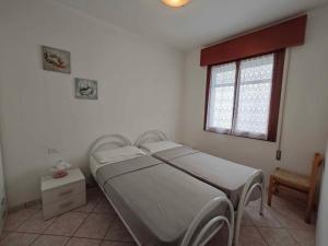 ein Schlafzimmer mit einem Bett und einem Fenster in der Unterkunft Apartments in Rosolina Mare 48309 in Rosolina Mare