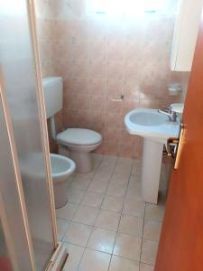 ein Badezimmer mit Toilette und Waschbecken in der Unterkunft Apartments in Rosolina Mare 48309 in Rosolina Mare + 9 Fotos