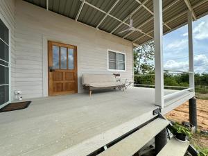 a porch of a white house with a couch on it at 29 Palms Thailand in Ban Klang