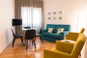 un soggiorno con un divano blu e un tavolo di Casa das Aguarelas - Apartamentos a Ericeira