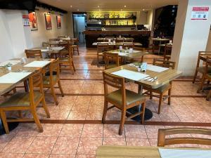 a restaurant with wooden tables and chairs and a piano at Hotel El Salvador in Mexico City