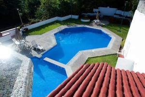 a large blue swimming pool with a red roof at Hermosa Villa en Ixtapa Zihuatanejo ideal para Parejas y Familia in Ixtapa +8 photos