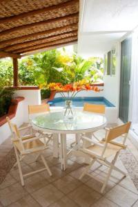 a table with chairs and a vase with flowers on it at Hermosa Villa en Ixtapa Zihuatanejo ideal para Parejas y Familia in Ixtapa