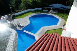 a large blue swimming pool with a red roof at Hermosa Villa en Ixtapa Zihuatanejo ideal para Parejas y Familia in Ixtapa
