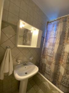 a bathroom with a sink and a shower with a mirror at Seaside House in AgiaKampos