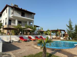 a resort with a pool and chairs and a building at Astri Villa in Ierissos
