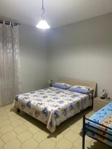 a bedroom with a bed with blue and white sheets at Holiday House in Taviano