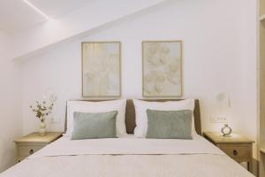 a bedroom with a white bed with two tables at Pasiphae Luxury villa in Agia Pelagia +23 photos