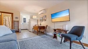 a living room with a bed and a desk and a tv at Beachside Oceanside Walk onto the beach in Saco