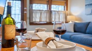 a table with a bottle of wine and two glasses at Beachside Oceanside Walk onto the beach in Saco