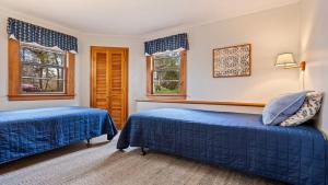 two beds in a room with two windows at Beachside Oceanside Walk onto the beach in Saco +21 photos