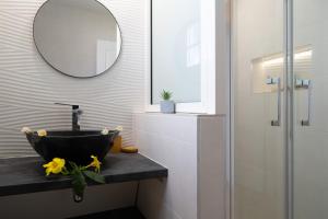a bathroom with a black sink and a mirror at Appartement la marine in Saint-Leu +12 photos