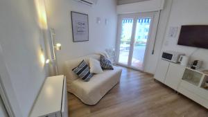 ein weißes Wohnzimmer mit einem Sofa und einem TV in der Unterkunft Casa Sardina in San Benedetto del Tronto