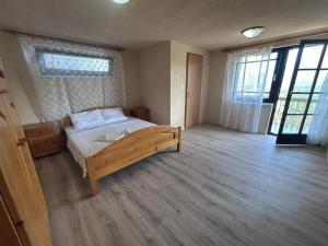 a bedroom with a bed in a room with windows at Apartman MK in Kruče