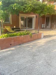 a building with a garden with a yellow chair in front of it at Bas de villa 2 à 5 couchages in Évenos +1 photo