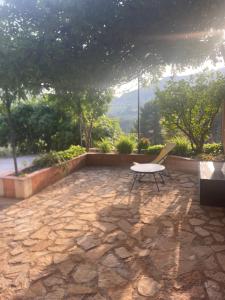a patio with a table and a chair on a stone floor at Bas de villa 2 à 5 couchages in Évenos