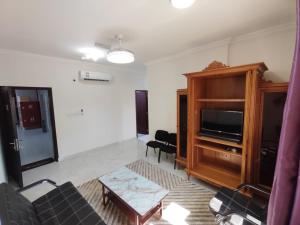 a living room with a couch and a tv at Al Anwar Building Luxury in Salalah