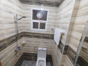a bathroom with a toilet and a shower and a window at Al Anwar Building Luxury in Salalah +6 photos