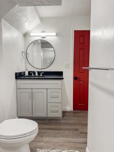 a bathroom with a toilet and a red door at Newly Renovated 5 BR 3 Bth in SLC in Salt Lake City