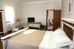 a bedroom with a large bed and a television at Virò House in Squinzano