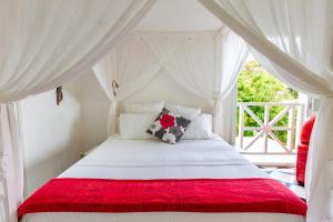 1 dormitorio con cama blanca y manta roja en TOUDOU DOUDOU, en Deshaies 32 fotos más
