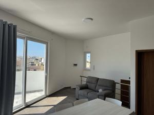 a living room with a chair and a window at Cozy 1-Bedroom Penthouse - by HostMT in Taʼ Penza